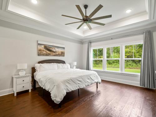 Un dormitorio con una cama y un ventilador de techo. en Timber and Tides, en Crawfordville