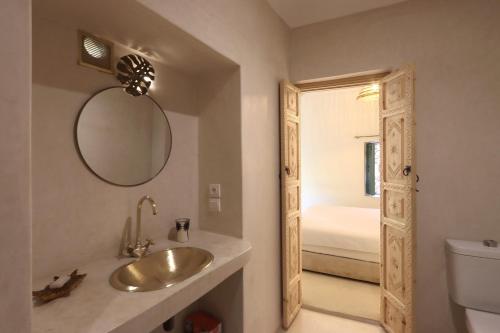 a bathroom with a sink and a mirror and a toilet at Riad NaaNaa Bed & Breakfast in Marrakech