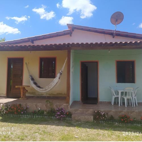 a house with a hammock in front of it at Chalé Canto do Sabiá in Ibicoara