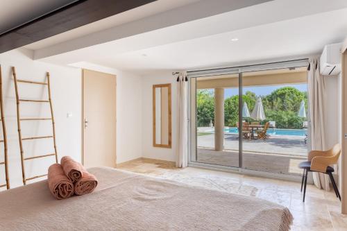 a bedroom with a bed and a view of a pool at Le mas sous les étoiles in Joucas