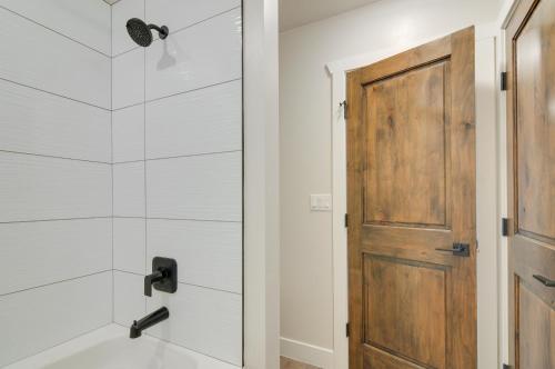 ein Badezimmer mit einer Dusche und einer Holztür in der Unterkunft Brian Head Retreat with Deck, Shuttle to Ski Slopes! in Brian Head