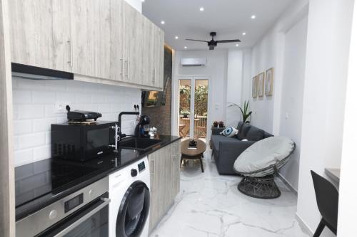 a kitchen with a washing machine and a living room at Zeos finest jacuzzi Suite in Athens