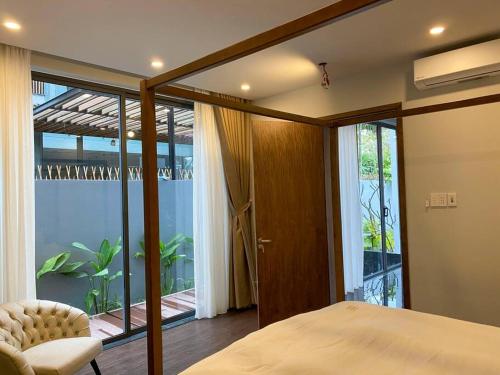 a bedroom with a bed and a large window at Song Cat villa - 49DP8 in Danang