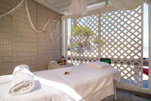 a white bed in a room with a window at Hotel Rivage Taormina in Taormina