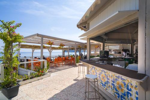 a patio with a bar with a view of the ocean at Hotel Rivage Taormina in Taormina