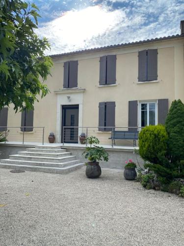 a large house with two potted plants in front of it at La belle Charentaise in Vaux-Rouillac
