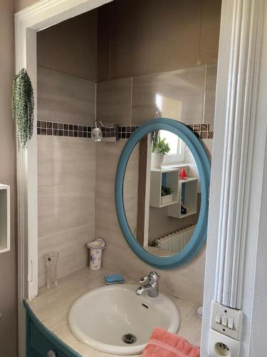 La salle de bains est pourvue d'un lavabo et d'un miroir bleu. dans l'établissement La belle Charentaise, à Vaux-Rouillac