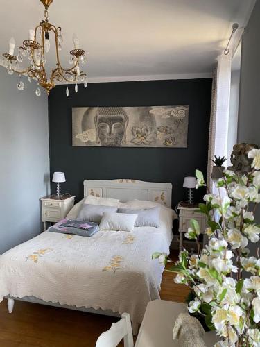- une chambre avec un lit blanc et un mur noir dans l'établissement La belle Charentaise, à Vaux-Rouillac