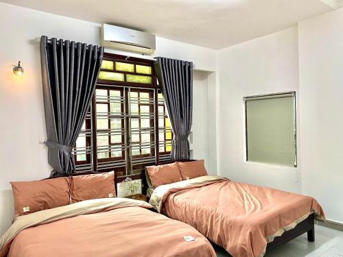 1 dormitorio con 2 camas y ventana en Shine Riverside Homestay, en Hue