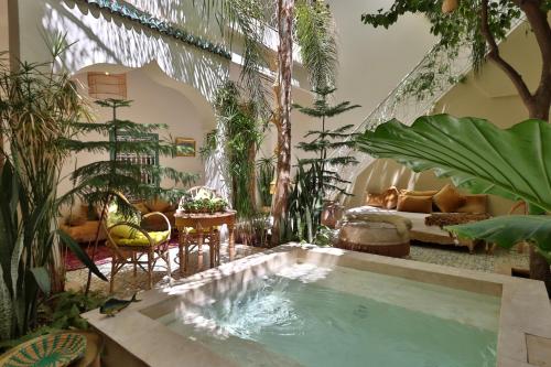 a living room with an indoor pool with plants at Riad NaaNaa Bed & Breakfast in Marrakech