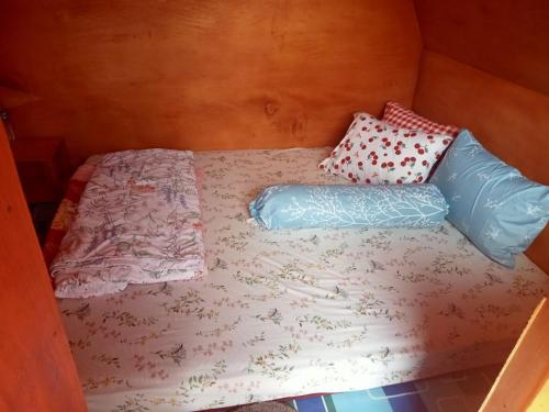 a bed with two pillows on it in a room at Homestay Subarda Kamar Natural in Solok