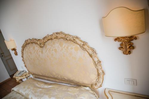 a chair in a room with a lamp on a wall at Relais San Giacomo in Maiori