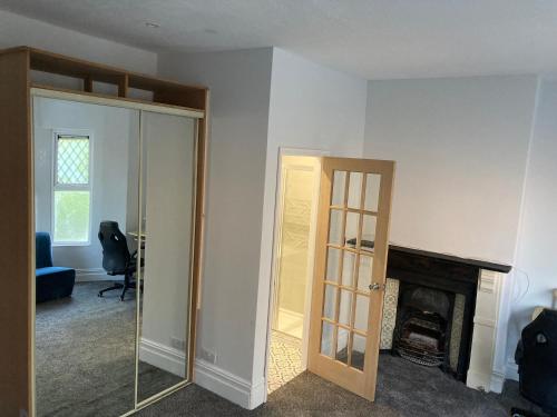 une pièce vide avec une cheminée et un miroir dans l'établissement En-suite room near, à Cardiff