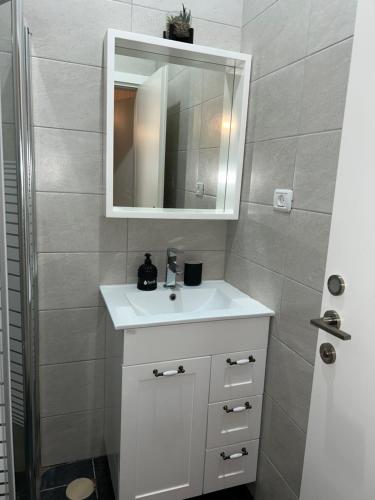 a bathroom with a white sink and a mirror at Suite 24/7-סוויטת 24/7 in Ramat Gan