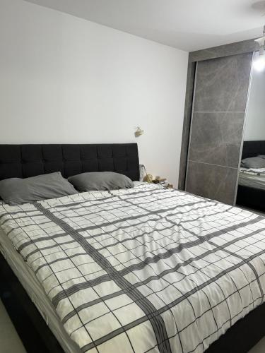 a bedroom with a bed with a checkered blanket at Suite 24/7-סוויטת 24/7 in Ramat Gan