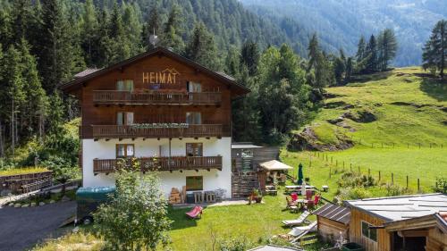 a hotel with a balcony in a mountain at Heimat - Das Natur Resort in Prägraten