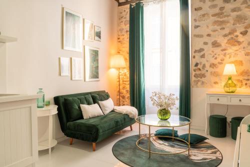 un salon avec un canapé vert et une table dans l'établissement Le Cosy Safranier Vieil Antibes, à Antibes