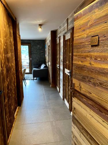 un pasillo con paredes de madera y una habitación con sofá en Appartement au pied des pistes - Olvera 403, en Valmeinier