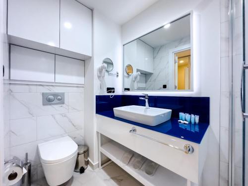 a bathroom with a sink and a toilet and a mirror at ORBI CITY Beautiful Luxurios Panoramic View on batumi in Batumi