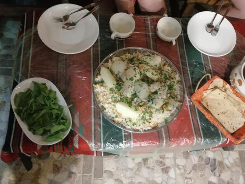 una mesa con un plato de comida en una mesa en Petra Glamour Hostel, en Taiyiba