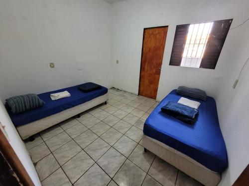 a room with two beds and a window and a door at ADE águas claras 01 in Brasilia