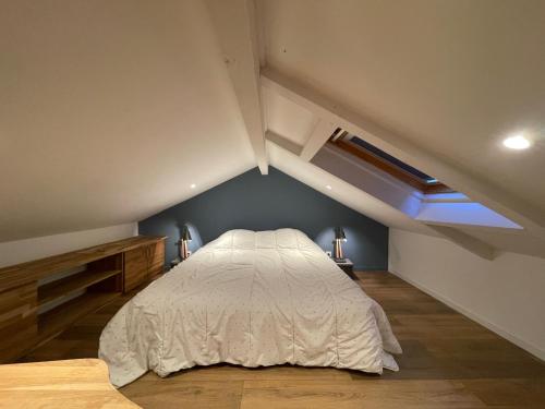 a bedroom with a white bed in the attic at maison colmars in Colmars