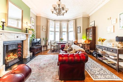 a living room with a red couch and a fireplace at The Regency Studio at 82 Cathedral in Cardiff