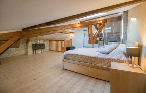 ein Schlafzimmer mit einem großen Bett in einem Zimmer mit Holzböden in der Unterkunft Nice Apartment In Puisseguin With Wi-fi in Puisseguin