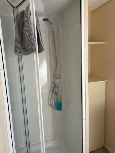 a shower with a glass door in a bathroom at Parkdean cherry tree holiday park Burgh castle Great Yarmouth in Belton