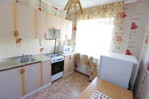 a small kitchen with a sink and a refrigerator at Строймарт in Petropavlovsk