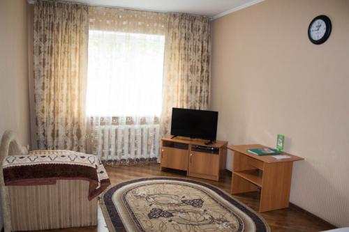 a living room with a television and a rug at Строймарт in Petropavlovsk