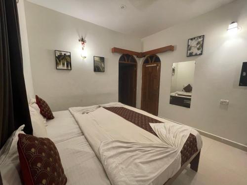 a bedroom with a bed and a mirror on the wall at Baga View Inn in Baga