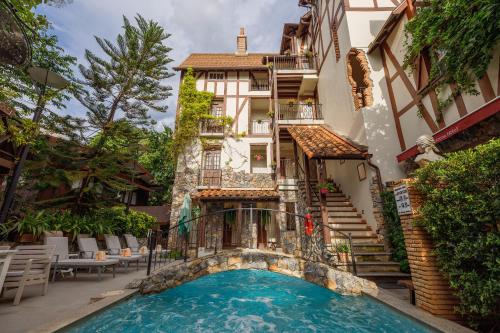 a hotel with a swimming pool in front of a building at Le Charcoa Hotel in Chiang Mai