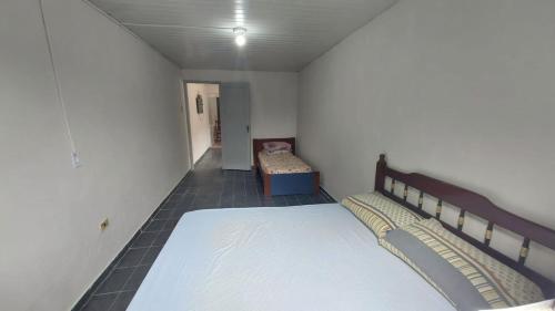 a bedroom with two beds and a chair in it at Mares do Sul in São Vicente