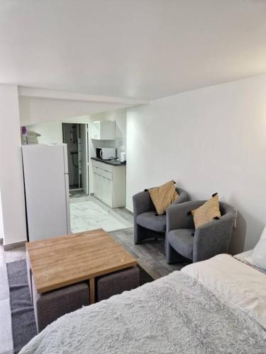 Cette chambre comprend un lit, deux chaises et une table. dans l'établissement StudioNeuf équipé CDG/Parc Expo/ Paris, à Aulnay-sous-Bois