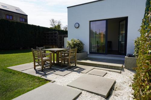 een patio met een tafel en stoelen in een tuin bij Gîte de la Côte Dor : logement zen à la campagne in Fosses-La-Ville