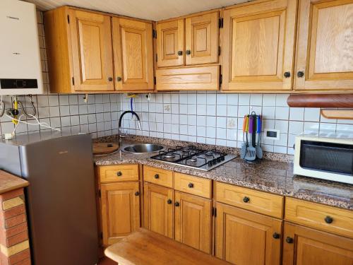 a kitchen with wooden cabinets and a stove top oven at Gabry House-Venezia Mestre in Zelo