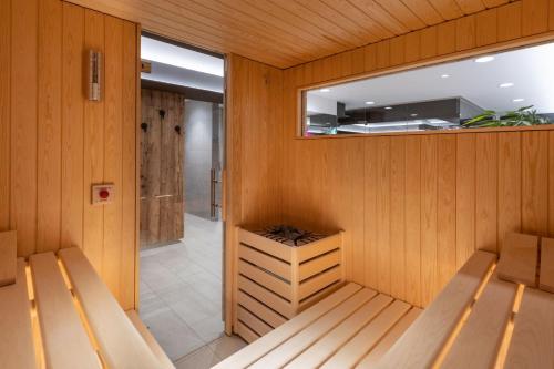 a sauna with wooden walls and benches and a mirror at Melchtal Resort Apart Hotel in Melchtal