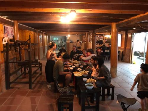 un grupo de personas sentadas en una mesa en un restaurante en Vietoutdoors Homestay, en Sa Pa