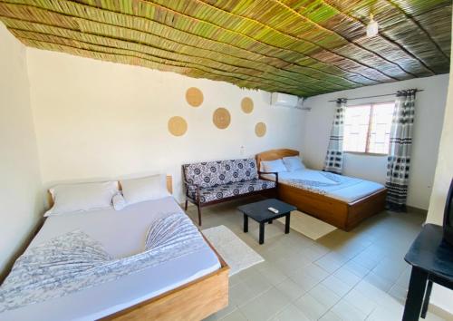 a living room with two beds and a couch at Le Dona Kribi in Kribi