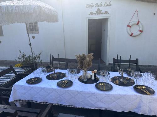 a table with a blue table cloth and plates and glasses at Casa Bella in Palić