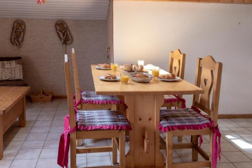 - une table en bois avec des chaises et des bols de nourriture dans l'établissement Chalet Rochebrune - Apartment Mont-Chery, aux Gets