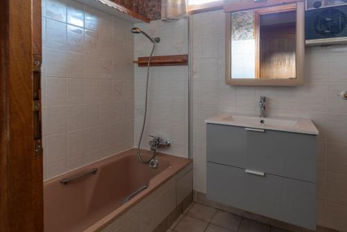une salle de bain avec une baignoire et un lavabo et une baignoire dans l'établissement Chalet Rochebrune - Apartment Mont-Chery, aux Gets