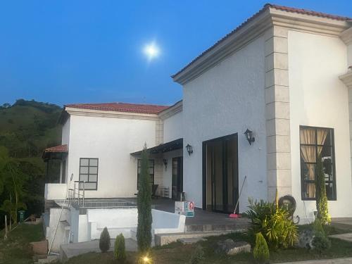 a white house with a courtyard in front of it at Villa Venecia Colonial in Venecia