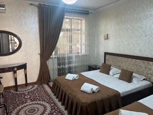 a hotel room with two beds and a window at Hotel Al-Bukhory in Samarkand