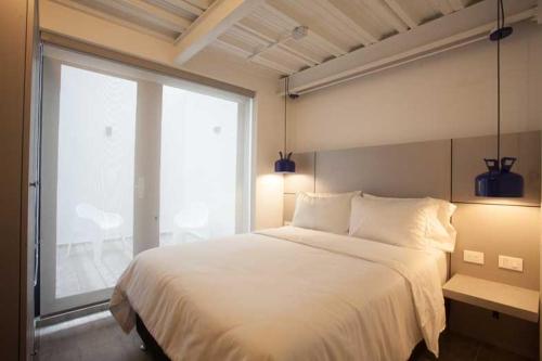 a bedroom with a large bed and a large window at Villaviciosa Hotel Boutique in Pasto
