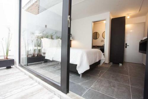a bedroom with a white bed and a mirror at Villaviciosa Hotel Boutique in Pasto