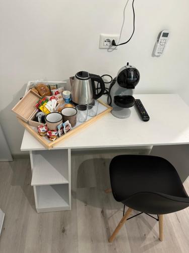 einen Schreibtisch mit einer Teekanne und einem Stuhl darauf in der Unterkunft Altopiano Rooms in Foggia