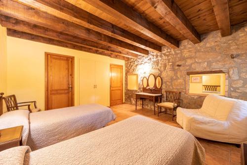 LladursにあるCasa Cobert del Carroの石壁のベッドルーム1室(ベッド2台付)