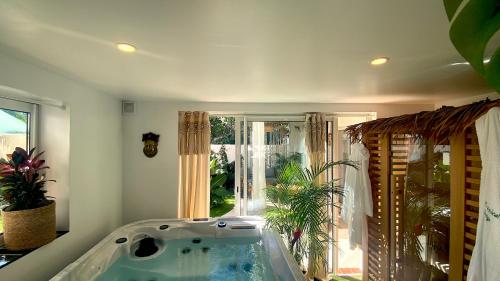 a bath tub in a room with a large window at Tropical Lodge SPA Narbonne in Narbonne